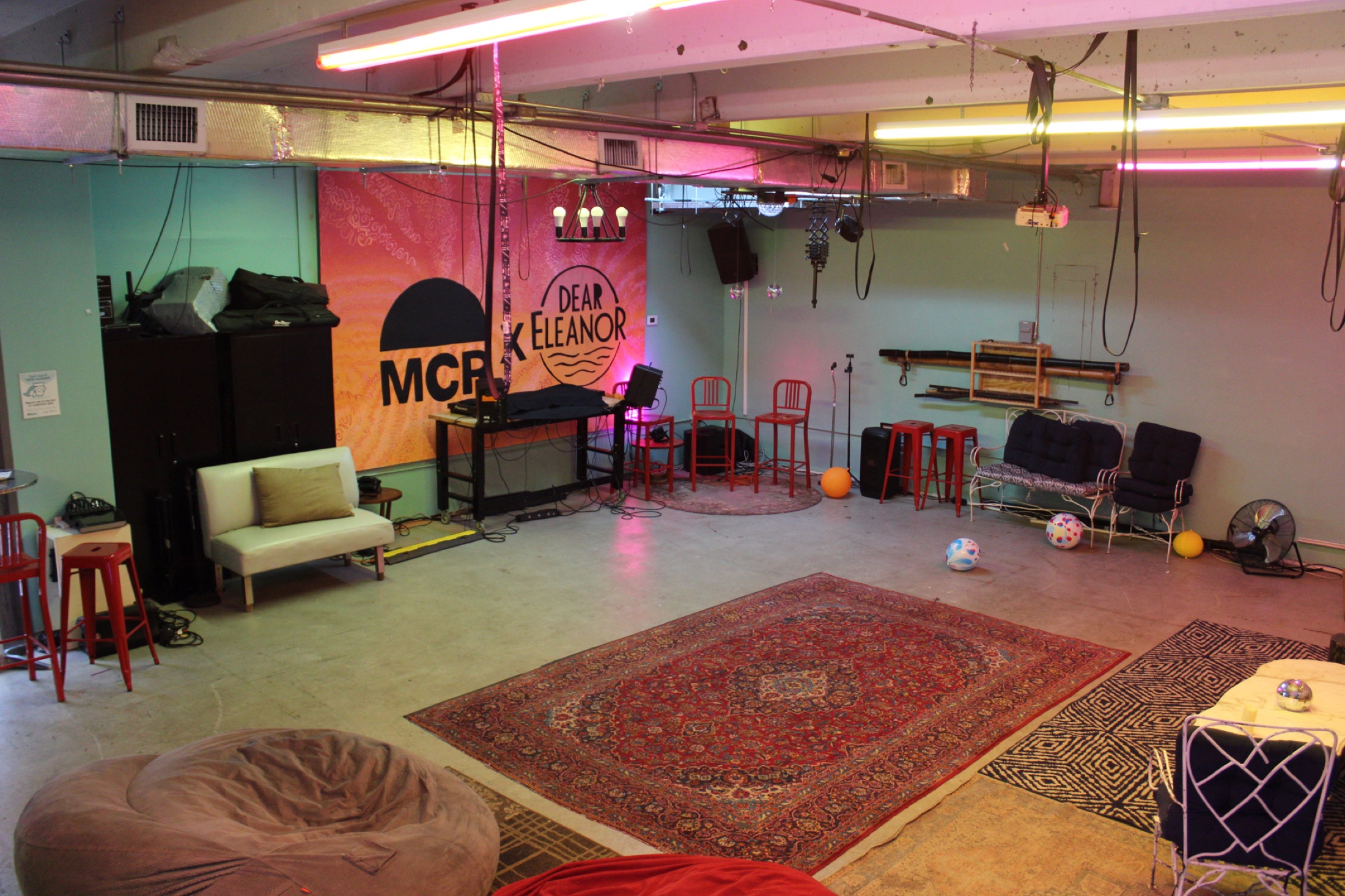 The open Dear Eleanor room with the Miami Community Radio wall and seating